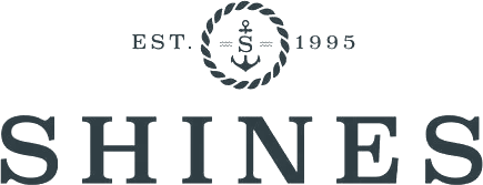 Logo reading "SHINES" in bold letters. Above, text says "EST. 1995" surrounding a rope circle with an anchor and the letter "S" inside.