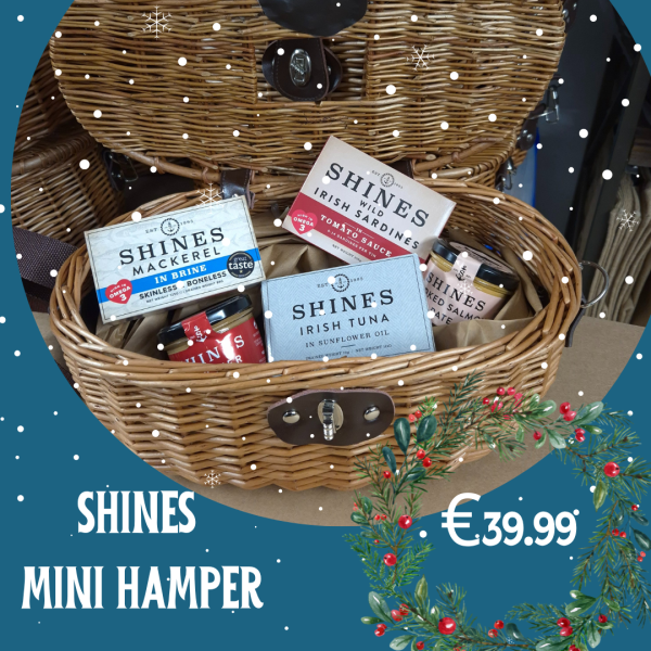 An open wicker hamper filled with the Mini Hamper is on display, snowflakes scattered across the image, with “The Mini Hamper £39.99” and festive decorations in the bottom right corner.