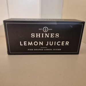 A black box labelled "Shines Lemon Juicer" with "Fish Shaped Lemon Juicer" printed below sits on a light surface.