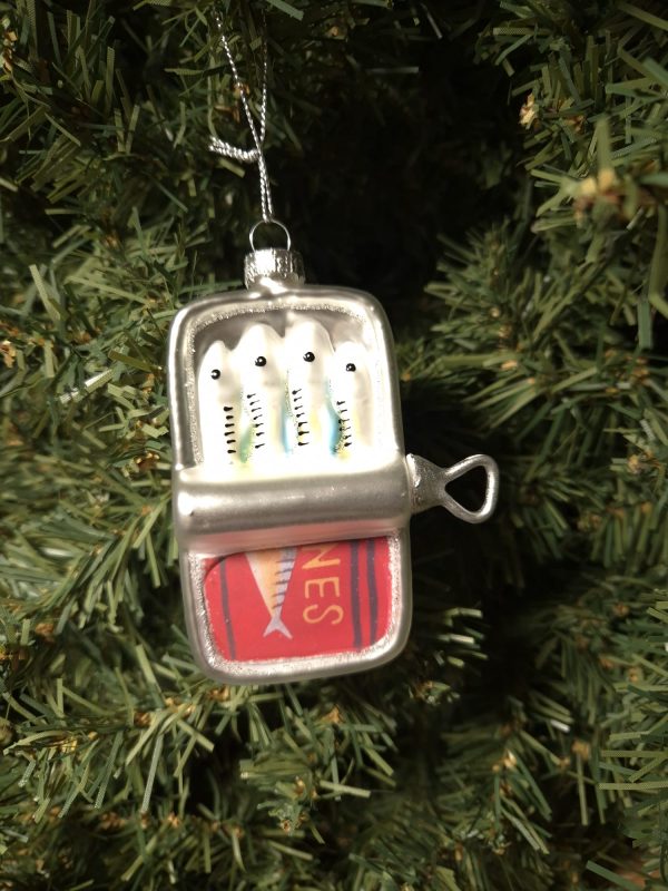 A lemon juicer ornament shaped like the Shines Lemon Juicer hangs on a green Christmas tree.